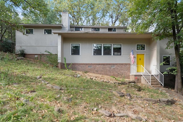 rear view of house with crawl space and a chimney