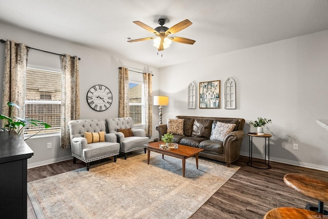 living room with a ceiling fan, baseboards, and wood finished floors