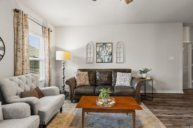 living room with ceiling fan, baseboards, and wood finished floors