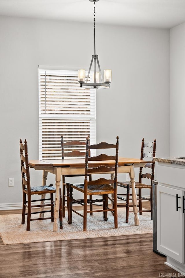 dining room with dark wood-style floors, a chandelier, and baseboards