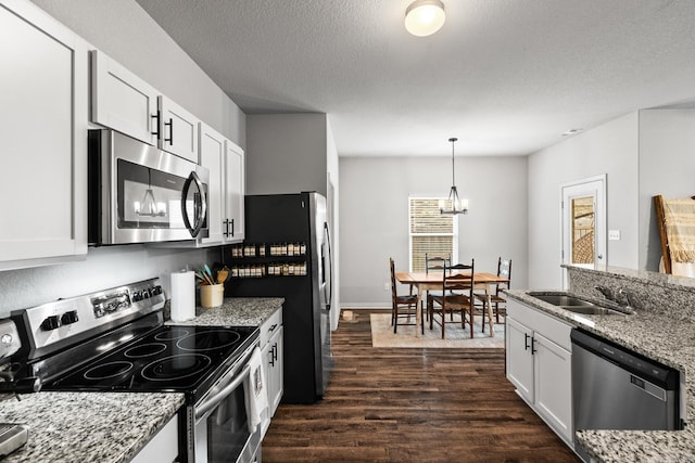 kitchen with appliances with stainless steel finishes, dark wood-style flooring, white cabinetry, and a sink