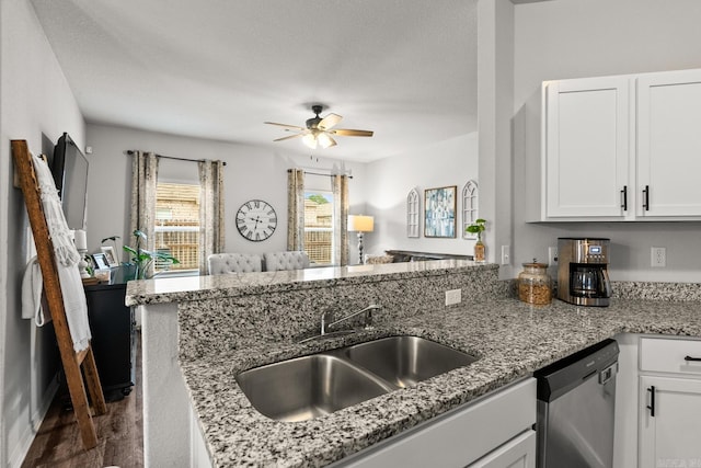 kitchen with a sink, a peninsula, white cabinetry, and stainless steel dishwasher