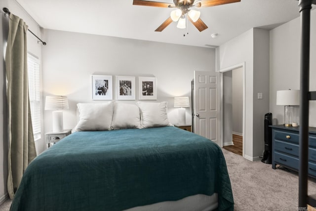 bedroom with ceiling fan, baseboards, and light colored carpet