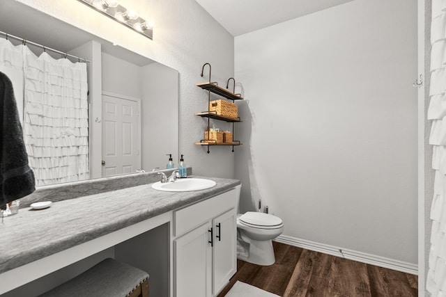 full bathroom featuring baseboards, vanity, toilet, and wood finished floors