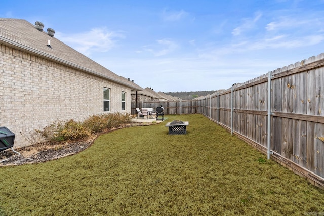 view of yard with an outdoor fire pit, a fenced backyard, and a patio