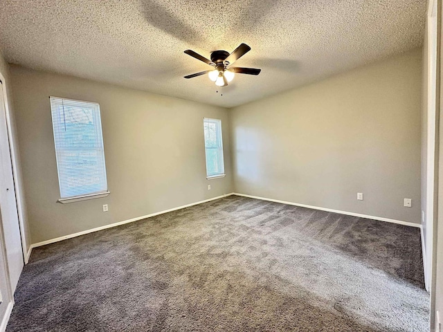 empty room featuring baseboards, a textured ceiling, dark carpet, and a ceiling fan