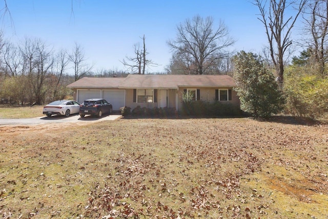 ranch-style home featuring a garage and driveway