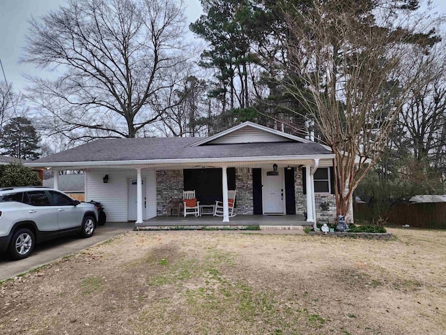 view of front of house featuring a porch, stone siding, and roof with shingles