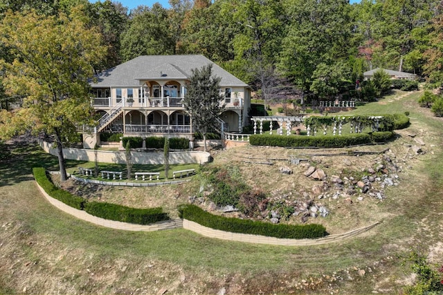 back of property featuring a lawn and stairway