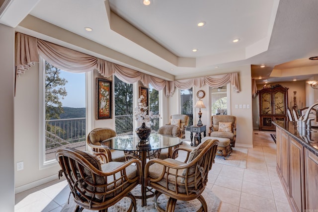 dining area featuring light tile patterned floors, baseboards, a tray ceiling, and recessed lighting