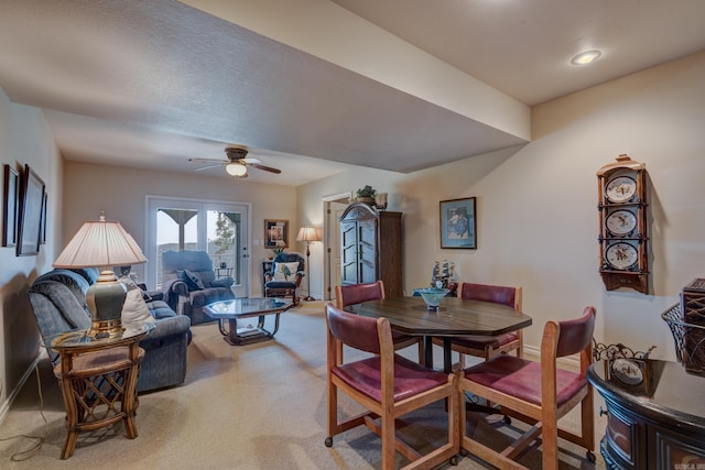 dining space with light carpet, a ceiling fan, and baseboards