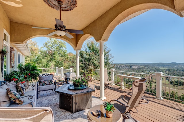 wooden deck featuring ceiling fan and an outdoor living space