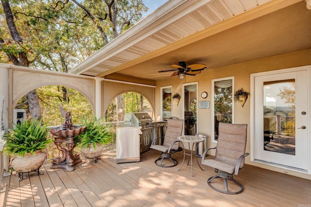 deck with ceiling fan and an outdoor kitchen