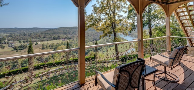 wooden terrace featuring a wooded view