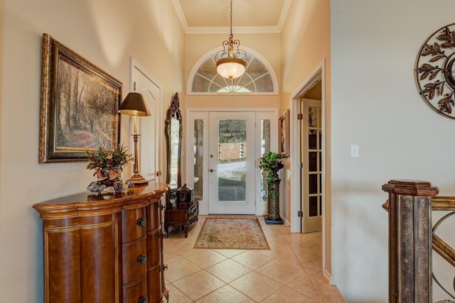 foyer with light tile patterned floors, ornamental molding, and baseboards