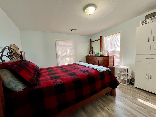 bedroom with visible vents and wood finished floors