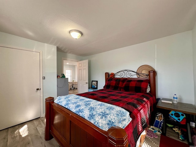 bedroom with light wood finished floors and a textured ceiling