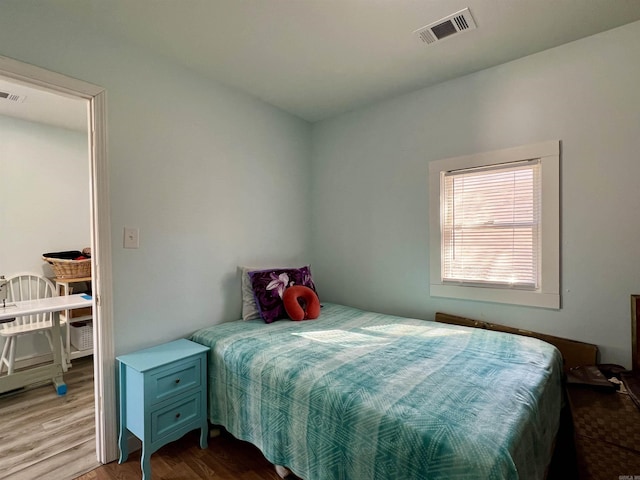 bedroom with wood finished floors and visible vents