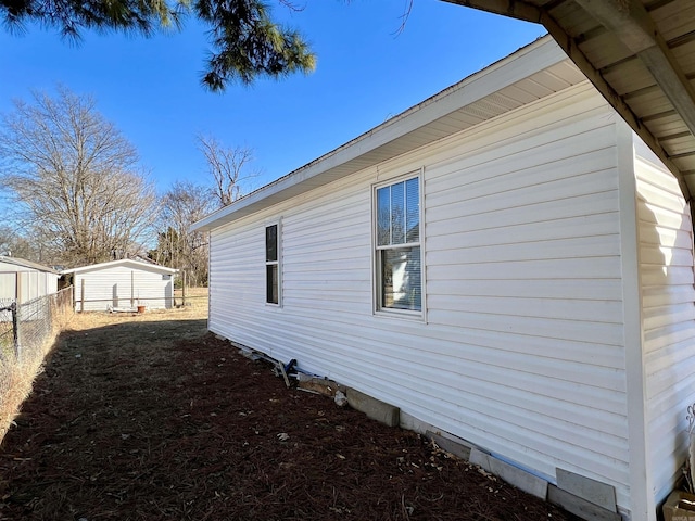 view of side of property with crawl space and fence