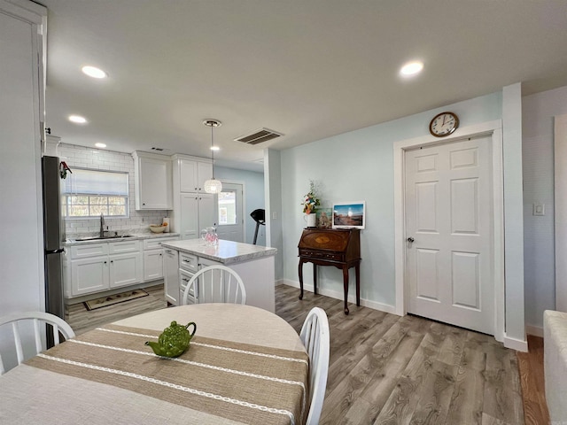 dining space with recessed lighting, light wood-type flooring, visible vents, and baseboards