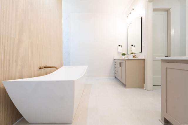 bathroom with a freestanding bath, vanity, and baseboards