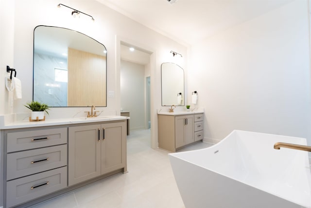 full bath featuring a soaking tub, two vanities, and a sink