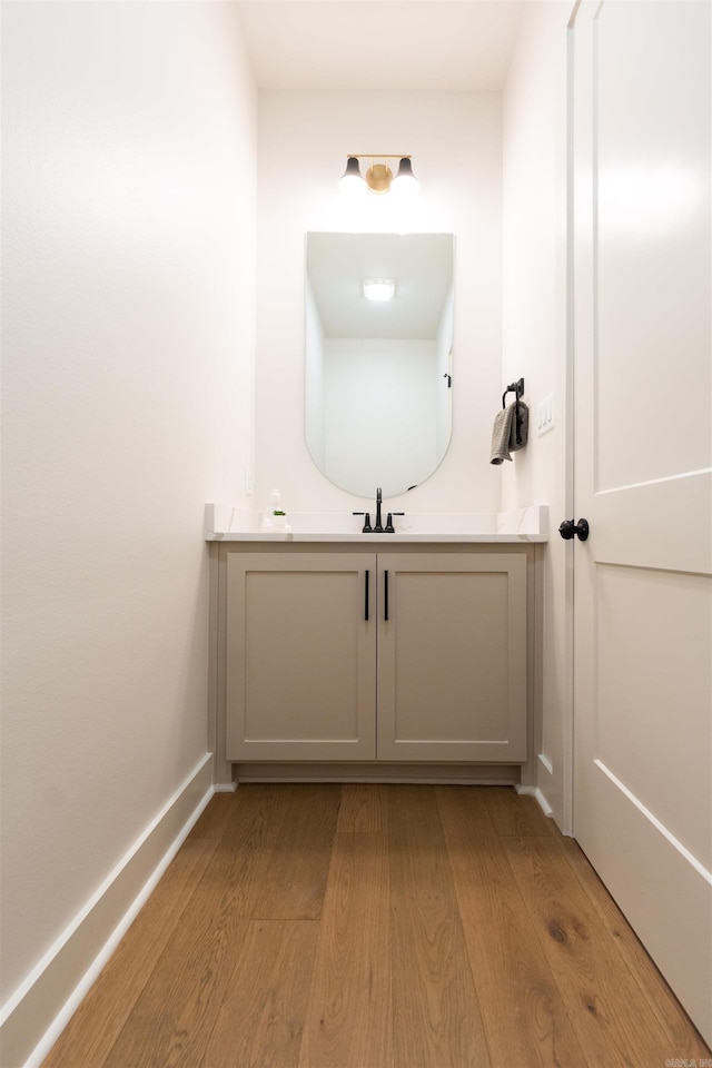 bathroom featuring wood finished floors, vanity, and baseboards