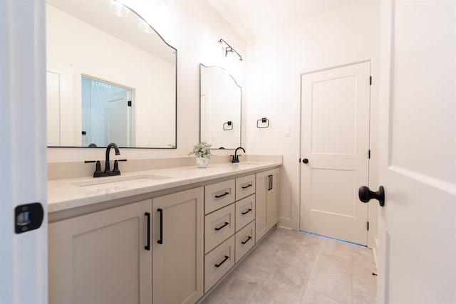 full bath featuring double vanity, tile patterned flooring, and a sink