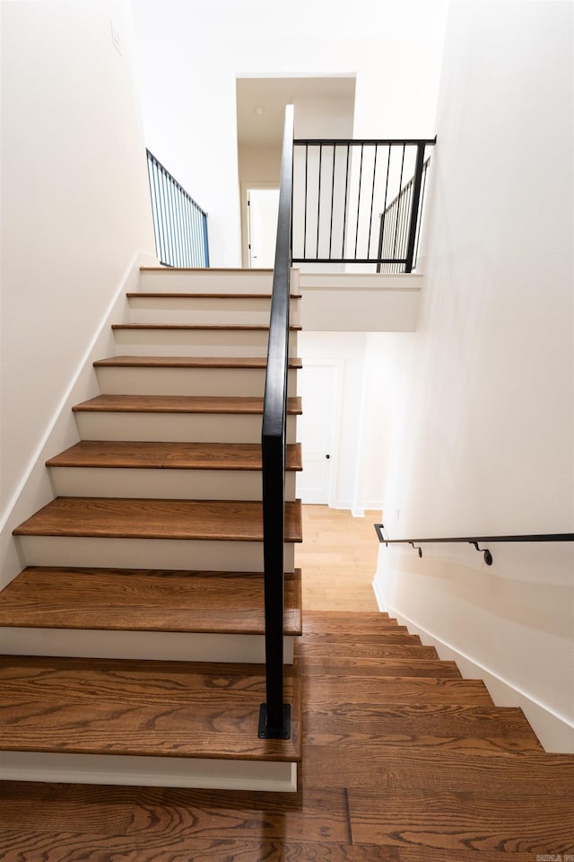 stairway featuring baseboards and wood finished floors