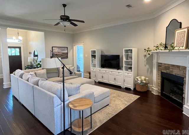 living area with dark wood-style flooring, crown molding, a fireplace, visible vents, and ceiling fan with notable chandelier