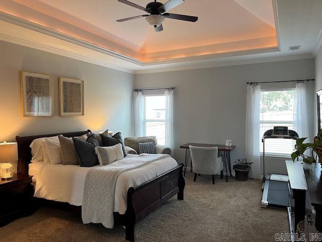 bedroom featuring multiple windows, dark carpet, a raised ceiling, and visible vents