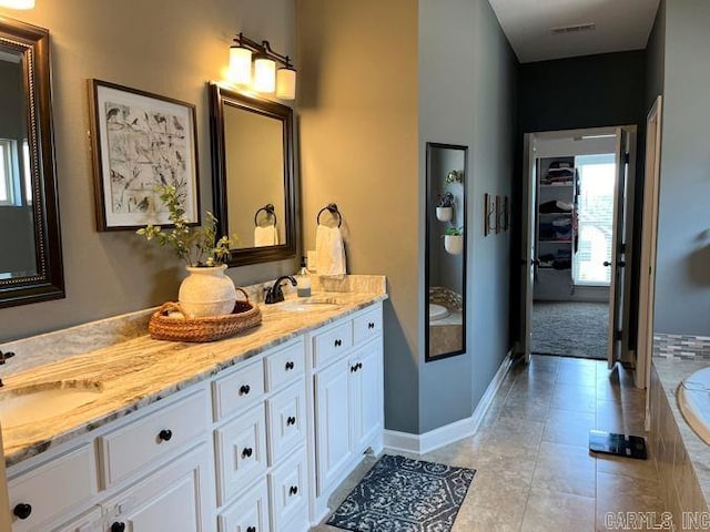 bathroom with tile patterned flooring, visible vents, a sink, and double vanity