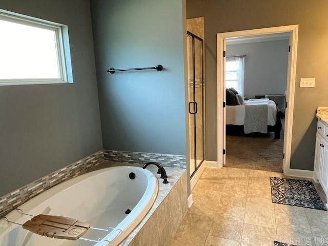 ensuite bathroom featuring ensuite bathroom, vanity, a shower stall, and a bath