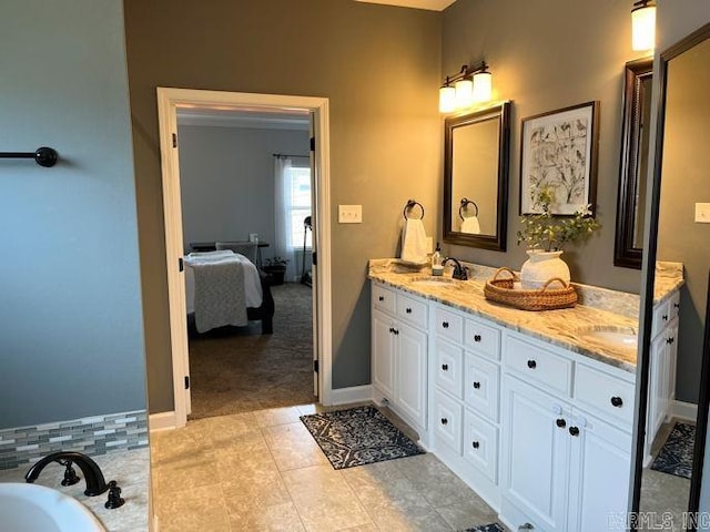 full bathroom with double vanity, baseboards, connected bathroom, tile patterned flooring, and a sink