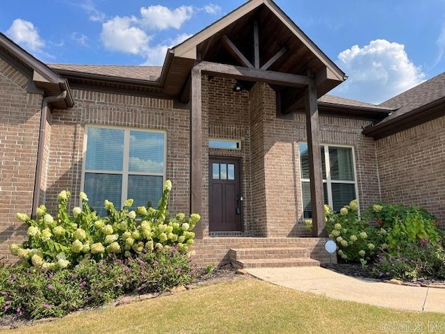 view of exterior entry featuring brick siding