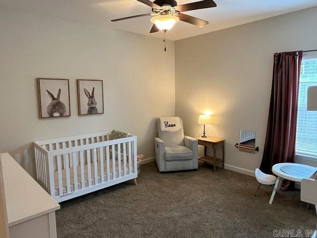 bedroom with a nursery area, carpet, a ceiling fan, and baseboards