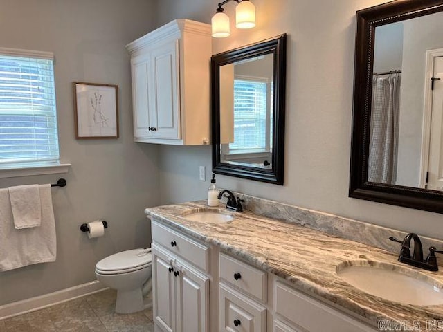 full bath with toilet, tile patterned flooring, double vanity, and a sink