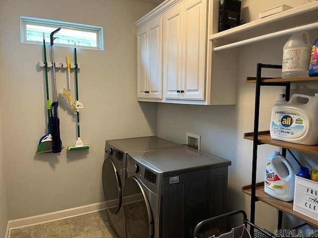 washroom with cabinet space, washing machine and dryer, and baseboards