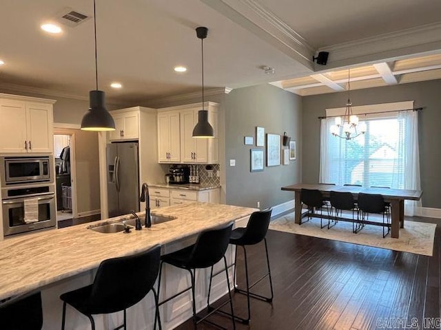 kitchen featuring tasteful backsplash, dark wood finished floors, coffered ceiling, appliances with stainless steel finishes, and a sink