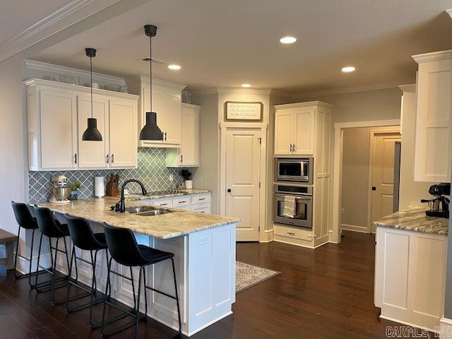 kitchen featuring stainless steel appliances, white cabinetry, a sink, and a peninsula