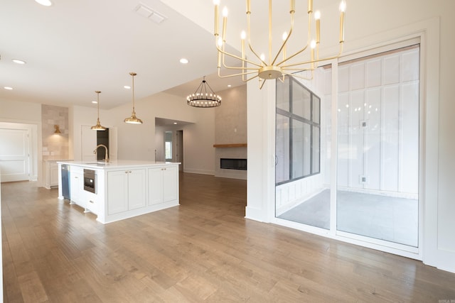 kitchen with visible vents, open floor plan, light countertops, light wood-style floors, and a sink