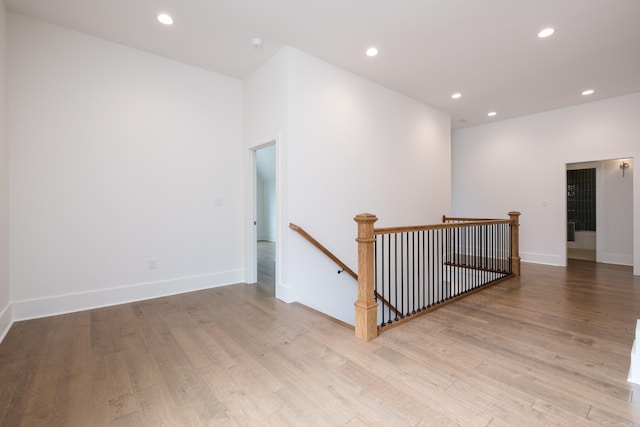 spare room featuring recessed lighting, baseboards, and wood finished floors