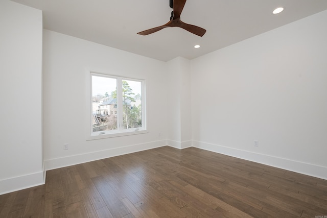 spare room featuring dark wood-style floors, recessed lighting, and baseboards