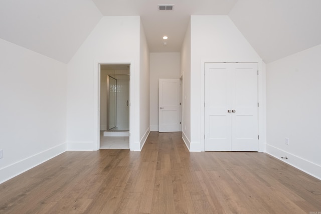 additional living space featuring visible vents, vaulted ceiling, baseboards, and wood finished floors