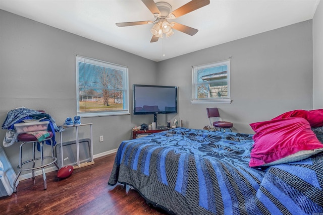 bedroom featuring a ceiling fan, baseboards, and wood finished floors