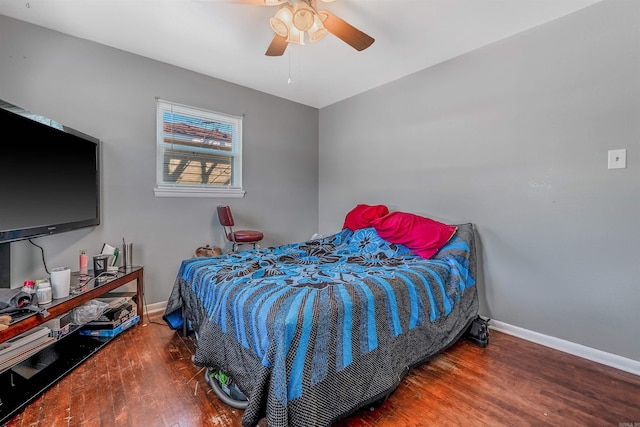 bedroom featuring a ceiling fan, baseboards, and wood finished floors