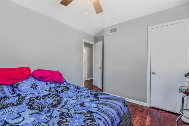 bedroom featuring a ceiling fan, visible vents, baseboards, and wood finished floors