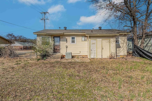 rear view of house with fence and a lawn