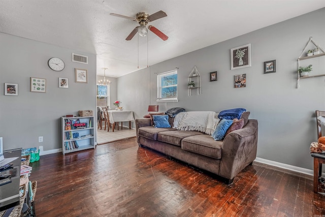 living area with hardwood / wood-style flooring, visible vents, a textured ceiling, baseboards, and ceiling fan with notable chandelier