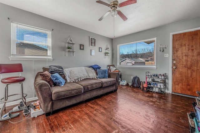 living room featuring a ceiling fan, baseboards, and wood finished floors